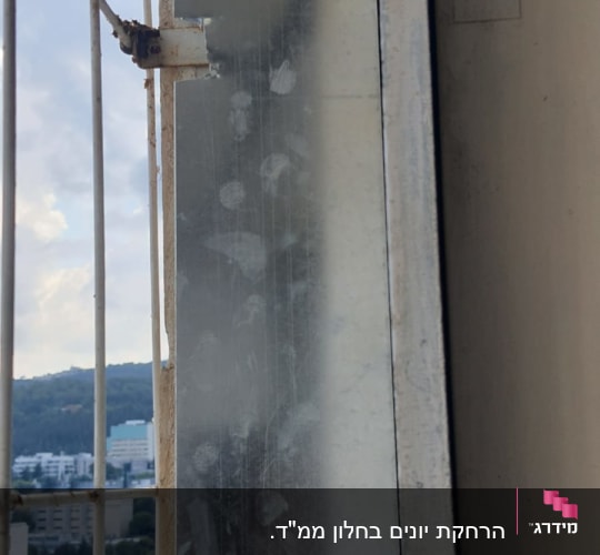 לוח מתכת עם סימני לכלוך, ליד סורגי מתכת